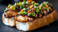 Grilled chicken breast topped with fresh herbs and nuts on toasted bread slices, gourmet appetizer or main course meal ready to serve.