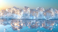 Melting ice cubes with water reflections against soft blue and orange sunset sky background create tranquil minimalist composition for cooling beverage concepts.