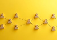 Wooden figures connected by black lines forming network pattern on yellow background, representing social connections, teamwork and organizational structure.