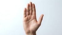 Open palm hand gesture showing stop sign against white background for communication and body language concepts.
