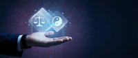 Businessman hand holding glowing digital icons of scales of justice and yin yang symbol, representing balance, ethics, and harmony in business decision making and corporate governance.