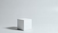 White geometric cube with shadow on neutral background for minimalist product display and modern design presentations.