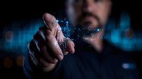 Male hand touching virtual interface with glowing digital data visualization, dark background with blue technology elements and bokeh lights.