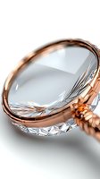 Magnifying glass with rose gold metal frame and crystal glass lens isolated on white background for design and product mockup use.