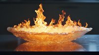 Dramatic orange flames dancing in a translucent ice bowl creating stunning contrast between fire and frozen water, reflecting on dark surface for artistic display.