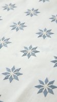 Seamless pattern with blue star flowers on cream fabric texture tiles perfectly for textile design wallpaper home decor and craft projects.