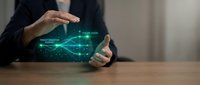 Professional businessman protecting digital data with holographic security interface and glowing green technology elements on wooden desk.