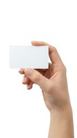 Hand holding blank white business card isolated on white background for mockup design and branding presentation.