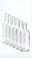 Empty clear glass bottles arranged in descending size order on white background, isolated for packaging design and beverage industry concepts.