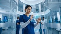 Asian female healthcare professional using digital tablet in modern medical facility with futuristic holographic interface technology for patient care.