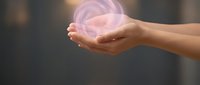 Hands holding glowing purple energy orb with magical light effect, representing power, spirituality, healing, and mystical concepts for wellness and alternative medicine applications.