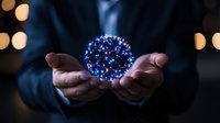 Glowing blue sphere of light particles floating between hands against dark background with bokeh lights, creating magical atmosphere for spiritual concepts.