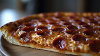 Freshly baked pepperoni pizza with melted cheese and crispy crust shown in close-up perspective, highlighting texture and glistening toppings for food photography.