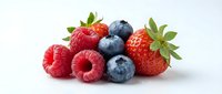 Fresh raspberries, strawberries and blueberries isolated on white background, ready for food and beverage design projects.