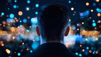 Back view of man silhouette against blurred city lights and bokeh background creating atmospheric night urban scene with dreamy mood and contemplative feeling.