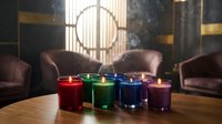 Colorful rainbow candles burning on wooden table in luxury living room with leather armchairs and dramatic lighting for home decor and relaxation.