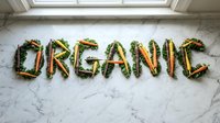 Word ORGANIC spelled with fresh colorful carrots and green kale leaves arranged on white marble surface, natural food concept.
