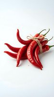 Fresh red chili peppers bundled with twine on white background, isolated and ready for culinary, food styling, recipe, and cooking-related design projects.