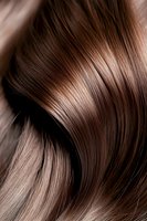 Luxurious brown hair waves close-up showing smooth, glossy texture and natural shine. Ideal for beauty, haircare product advertising and salon marketing materials.