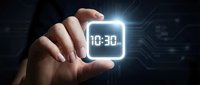 Hand holding glowing digital clock displaying 10:30 against dark tech background. Represents time management, deadline, scheduling, and business efficiency concepts.