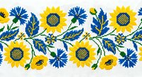 Traditional Ukrainian embroidery pattern with sunflowers and leaves in blue and yellow colors on white fabric background for textile design projects.