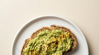 Avocado toast on sourdough bread with seeds and pepper, healthy breakfast meal on white plate, top view food photography for restaurant menu design.