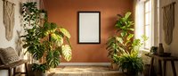 Boho living room interior with empty black frame mockup on terracotta wall, tropical plants, natural light, and rustic decor for art display.