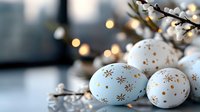 Decorative Easter eggs in pastel blue and white with delicate gold snowflake patterns arranged with illuminated branches creating festive holiday atmosphere.