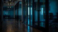 Modern office interior with glass partitions and blue lighting creating professional corporate workspace atmosphere for business presentations.