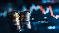 Stacked silver coins against financial chart background with dramatic lighting showing market volatility and trading concept for investment analysis.