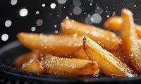Golden crispy french fries with salt crystals in cast iron skillet. Hot fast food potato wedges with steam and bokeh lights for restaurant menu design.