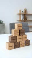 Wooden blocks with corporate values stacked in pyramid formation on white table in modern office interior for business ethics and leadership concepts.