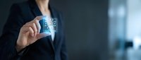 Professional businesswoman in dark suit holding transparent digital card with circuit board pattern for technology and finance presentations.