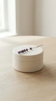 Minimalist wooden cosmetic jar with lavender sprig on natural wood surface in soft daylight for skincare and beauty product packaging design.