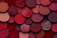 Assorted red and burgundy lipstick swatches arranged in overlapping circles, showcasing a rich palette of cosmetic shades for beauty and makeup concepts.