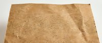 Vintage brown kraft paper texture with natural fibers and rough edges isolated on white background for eco-friendly packaging and rustic design projects.