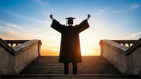 Graduate in cap and gown celebrating achievement with raised arms on stone steps at sunset, symbolizing academic success and future opportunities.