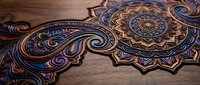 Intricate mandala design with ornate swirls and geometric patterns carved or engraved on wooden surface, featuring rich purple and gold accents for decorative art.