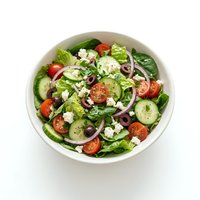 Fresh garden salad with mixed greens, tomatoes, cucumbers, red onions, and crumbled feta cheese in white bowl. Perfect for healthy eating, nutrition, and food styling.