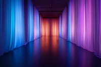 Illuminated corridor with flowing fabric curtains in vibrant blue, orange and purple creating dramatic perspective. Reflective floor adds depth and atmosphere.