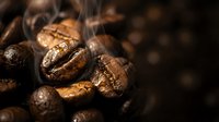 Aromatic roasted coffee beans with steam rising, showcasing rich brown textures and natural oils for cafe branding, beverage marketing and culinary designs.