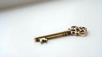 Ornate golden key with decorative filigree head isolated on white background, suitable for vintage design, antique concepts, security themes, and decorative applications.