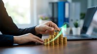 Businessperson stacking gold coins in growing columns with a green upward arrow, symbolizing financial growth, investment success, and wealth management.