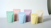 Colorful pastel stand-up pouches in mint green, coral pink, sky blue, lavender purple, sunny yellow and cream white arranged on neutral background.