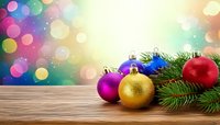 Colorful Christmas ornaments with fir branches on wooden table against festive bokeh background, perfect for holiday greeting cards and seasonal designs.