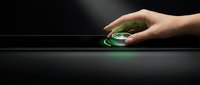 Caucasian hand holding glowing green gaming mouse on dark surface, technology and esports concept for web design and digital marketing.