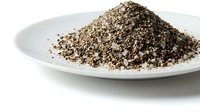 Ground black pepper spice pile on white plate isolated on white background for culinary cooking seasoning ingredient food preparation kitchen use.