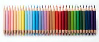 Assorted colored pencils arranged in a rainbow spectrum from pink through yellow, blue, purple, red, orange, and green shades on white background for art and design projects.