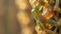 Colorful gemstone crystals with golden bokeh background creating luxury jewelry and mineral collection display for precious stone enthusiasts.