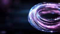 Glowing neon purple and blue light trails forming circular pattern against dark background, creating futuristic energy effect for technology concepts.
